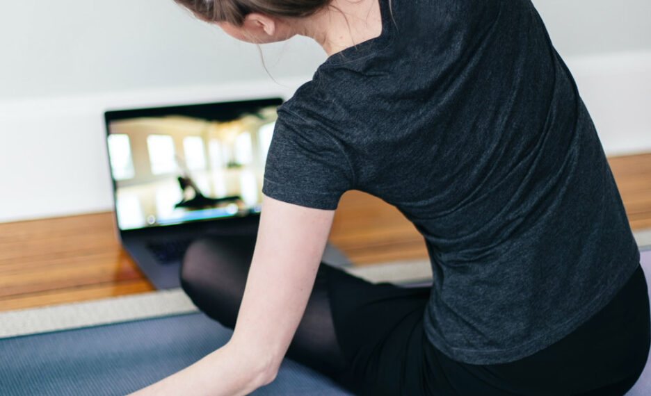 woman doing yoga in fron of laptop best yoga channels on youtube
