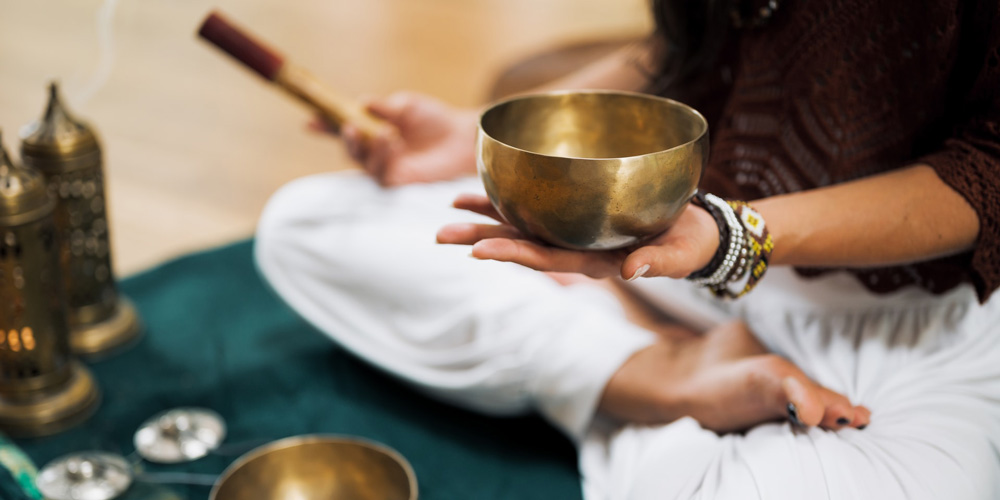 practitioner with singing bowl sound therapy